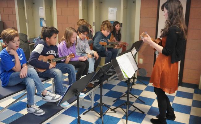 Third grade students performing their strings concert during lunch